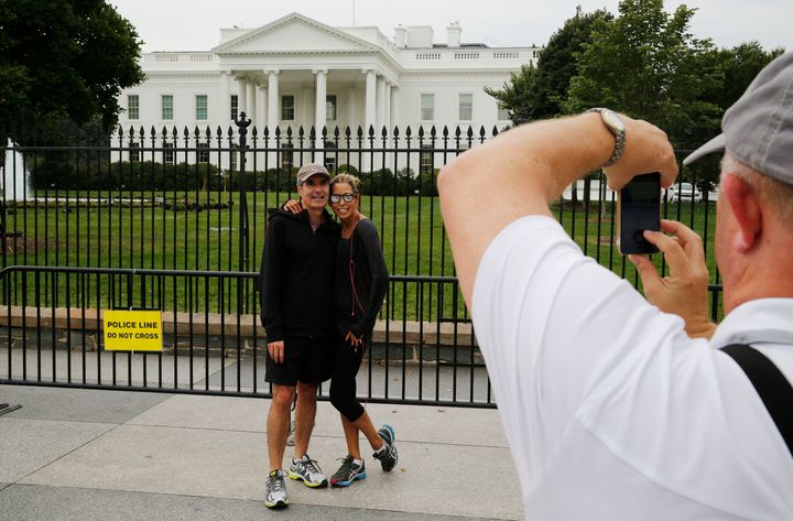 Tourists have their photograph taken from the sidewalk at the White House. The sidewalk will now be off-limits around the clock.