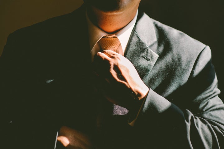 <p>Man adjusting tie</p>