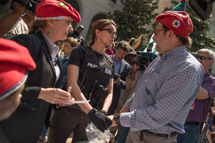 Adam Eidinger, right, of DCMJ, and RachelRamone Donlan, left, are stopped from handing out joints during Thursday's pot giveaway. The joint handout began again shortly thereafter.