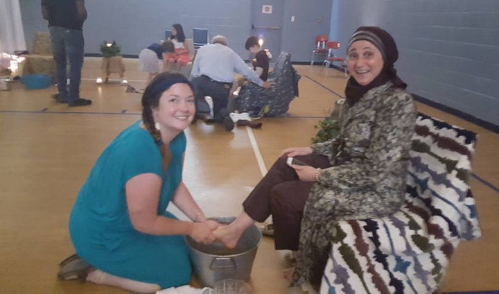 Rebecca Hart, a member of The Grove, washes the feet of Lina Sanjak, a volunteer.