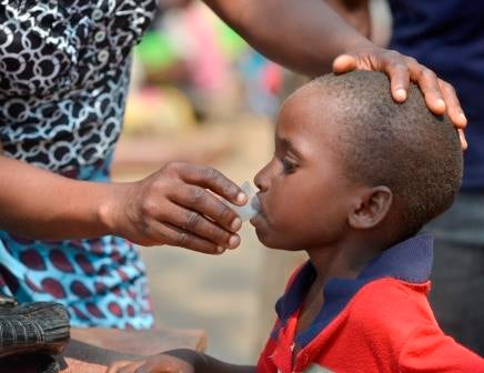 <em>A young boy takes antibiotic medication for trachoma. </em>