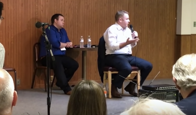 Rep. Warren Davidson (R-Ohio), seated in the white shirt, tells a woman her son should get a job that provides health insurance if he wants decent coverage.