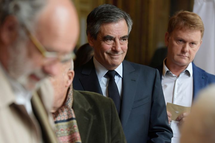 Francois Fillon (C), member of the Republicans political party and 2017 French presidential election candidate of the French centre-right, holds his ballot as he waits in line to vote in the first round of 2017 French presidential election in Paris, France, April 23, 2017. (REUTERS/Christophe Archambault/Pool)