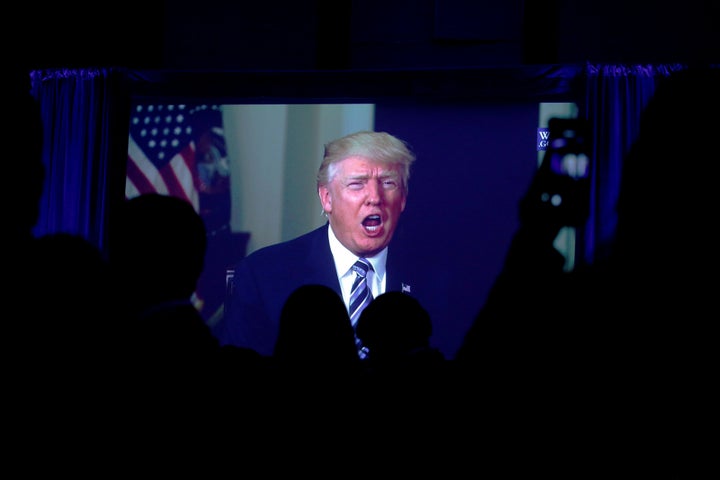 Guests watch a video of U.S. President Donald Trump as he addresses the 15th Plenary Assembly of the World Jewish Congress in New York City, U.S., April 23, 2017.