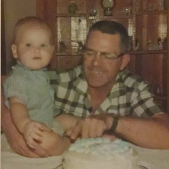 My grandfather holding me during my first birthday party.