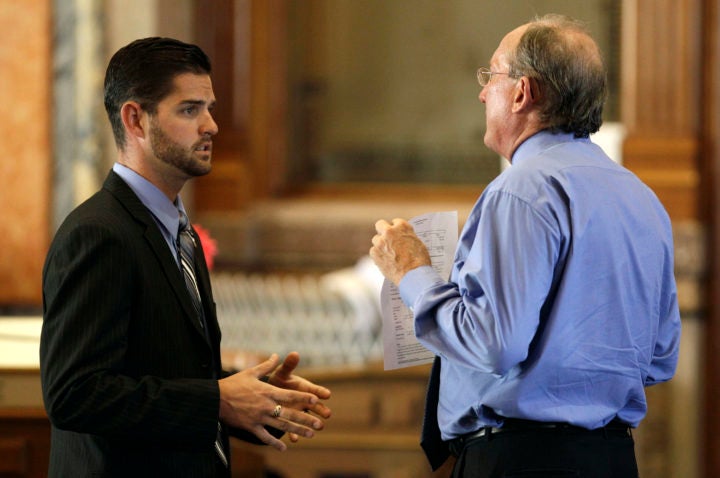 Representative Matt Windschitl (left), the sponsor of Iowa’s “stand your ground” law, speaks with a colleague at the state capitol in 2011. [AP Photo/Charlie Neibergall]