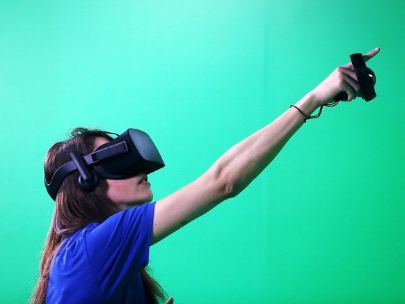 An attendee of Facebook's F8 Developer Conference uses an Oculus headset on April 18, 2017 in San Jose, CA.