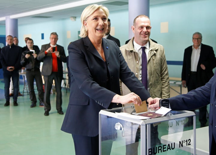 Marine Le Pen (L), a candidate for France's presidential election, casts her ballot in the first round of the election at a polling station in Henin-Beaumont, northern France, on Sunday.