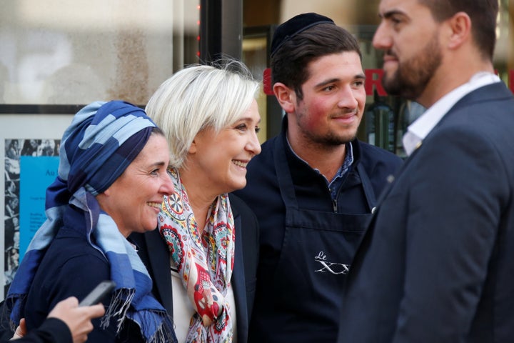 Marine Le Pen (C), French National Front (FN) political party leader and candidate for French 2017 presidential election poses in front of her campaign headquarters in Paris, France, April 24, 2017.