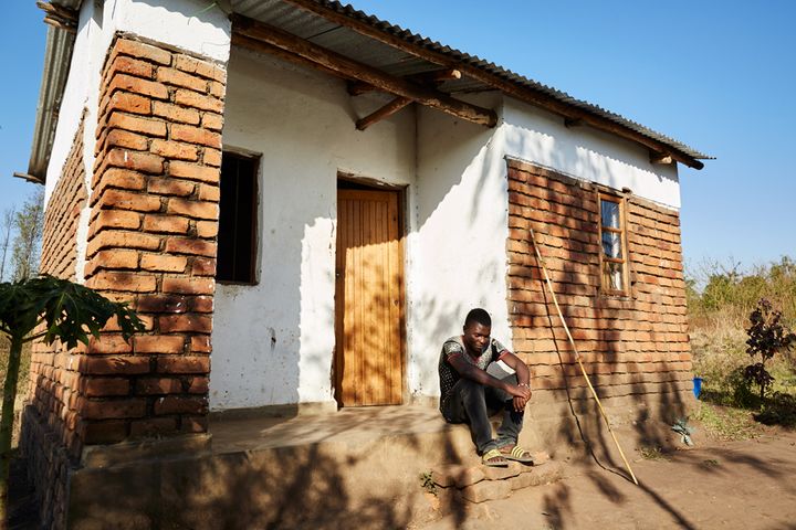 Peter (17), sits on the porch of his gowelo, Thyolo District, Malawi, 2016. After his parents died, Peter was found by a social worker and sent to a nearby orphanage, where he still lives today. Like several other children who are still at school, Peter rents out his gowelo, or lets relatives stay there, until he is old enough to live there himself. If Peter was president of Malawi he would “encourage people to build more houses, and lower the prices of building materials so that poor people like me can afford to live somewhere safe.”