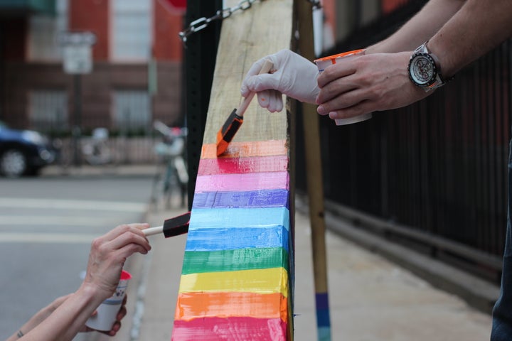 Gay St. residents painting a cross that appeared on their block.