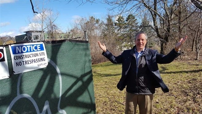 Bart Mitchell, who coordinates affordable housing projects in Boston, gestures to an empty lot where a new project is to be b
