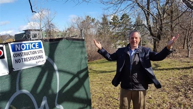 Bart Mitchell, who coordinates affordable housing projects in Boston, gestures to an empty lot where a new project is to be built. Financing for the project was thrown into disarray by the prospect of lower federal corporate tax rates.