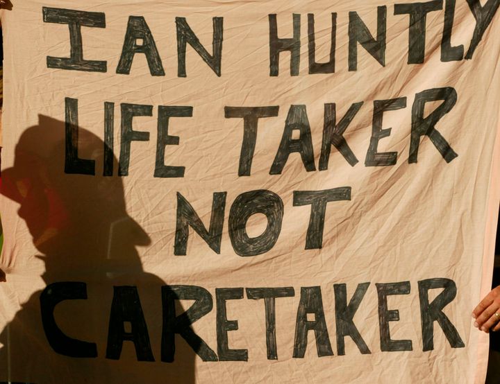 Protesters hold up a banner as Ian Huntley arrived at court to face murder charges in 2002 