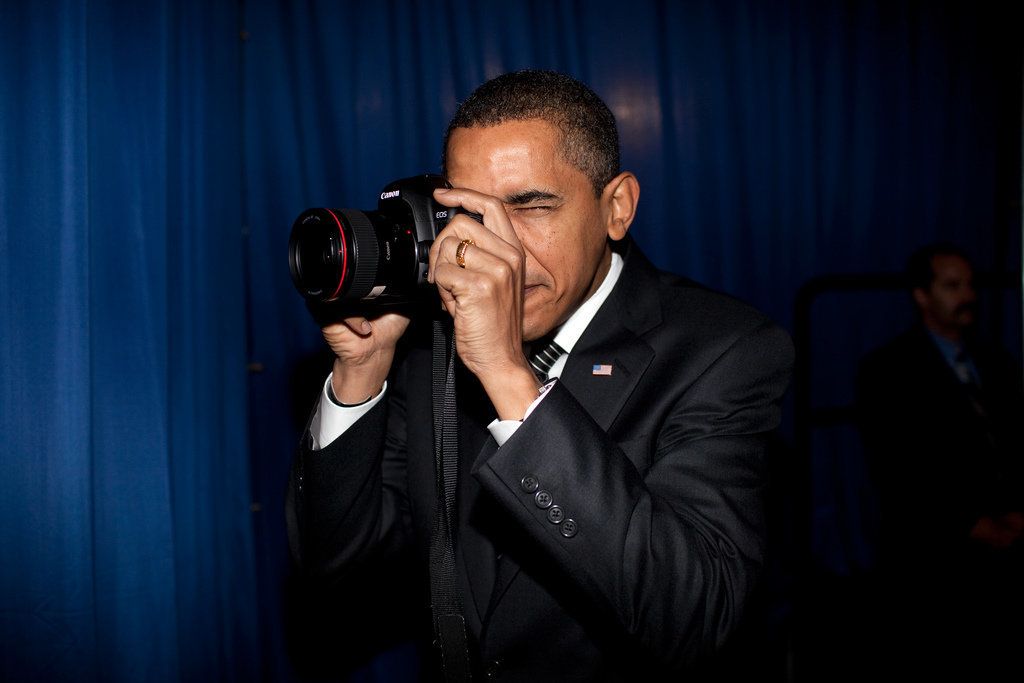President Barack Obama takes aim with a photographer's camera backstage prior to giving remarks about providing mortgage payment relief for responsible homeowners at Dobson High School in Mesa, Arizona, on Feb. 18, 2009.