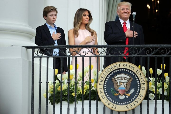 The President places his hand over his heart during playing of the national anthem, after an apparent reminder to do so from First Lady Melania Trump, at the White House Easter Egg Roll.