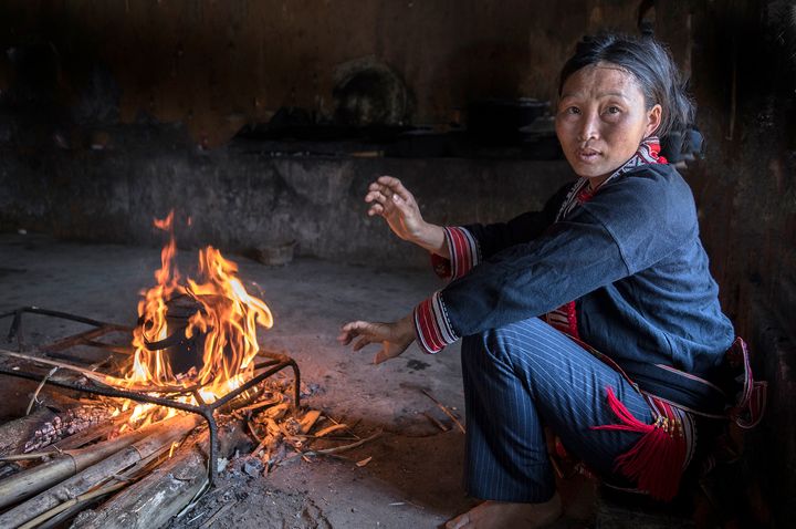 This woman is a member of the Tay ethnic group. She is boiling water to make green tea. All cooking is done on a open fire.