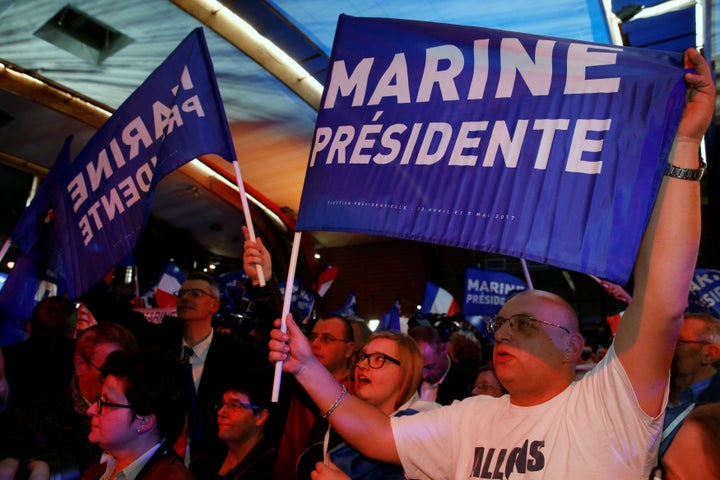 Supporters of Marine Le Pen hold flags as they wait for her arrival in Henin-Beaumont.