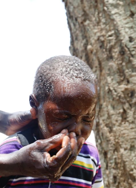 A boy having his face washed. Clean hands, clean faces free of mucus, and clean homesteads eliminate trachoma.