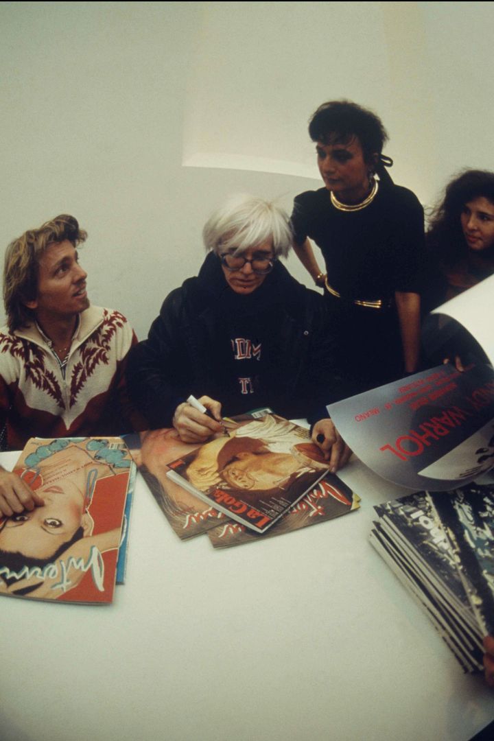 At the historic opening: Andy Warhol,flanked by Christopher Makos and Daniela Morera, signing autographs away. .