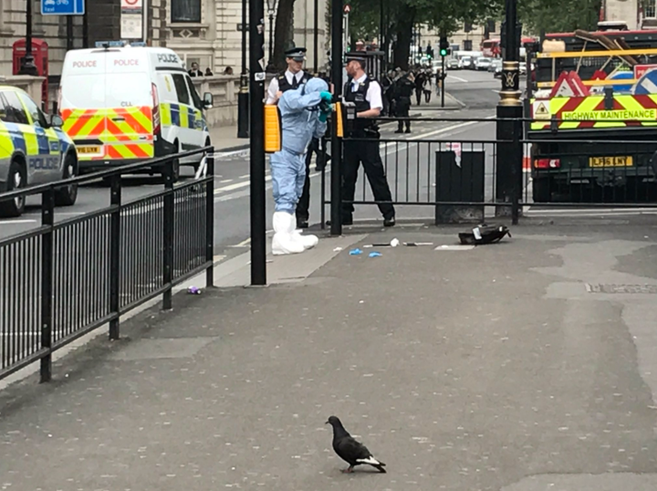 This picture shows at least two knives on the ground and a forensic officer collating evidence shortly after the incident