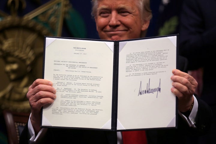 President Donald Trump shows off an executive action after signing it at the Pentagon on Jan. 27. He said this order would begin the rebuilding of the U.S. military by