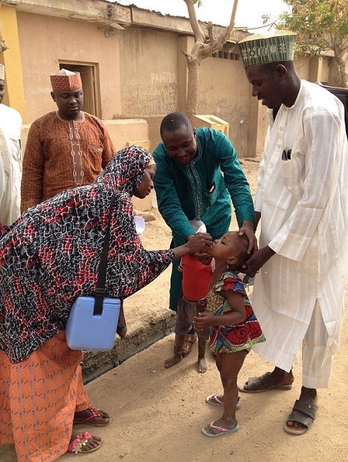 <p>A female health worker administers the polio vaccine to children in Nigeria. </p>