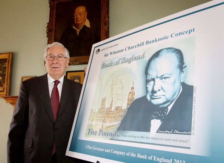 Former Bank of England governor Mervyn King with the note's original artwork (including quotation marks) when it was unveiled