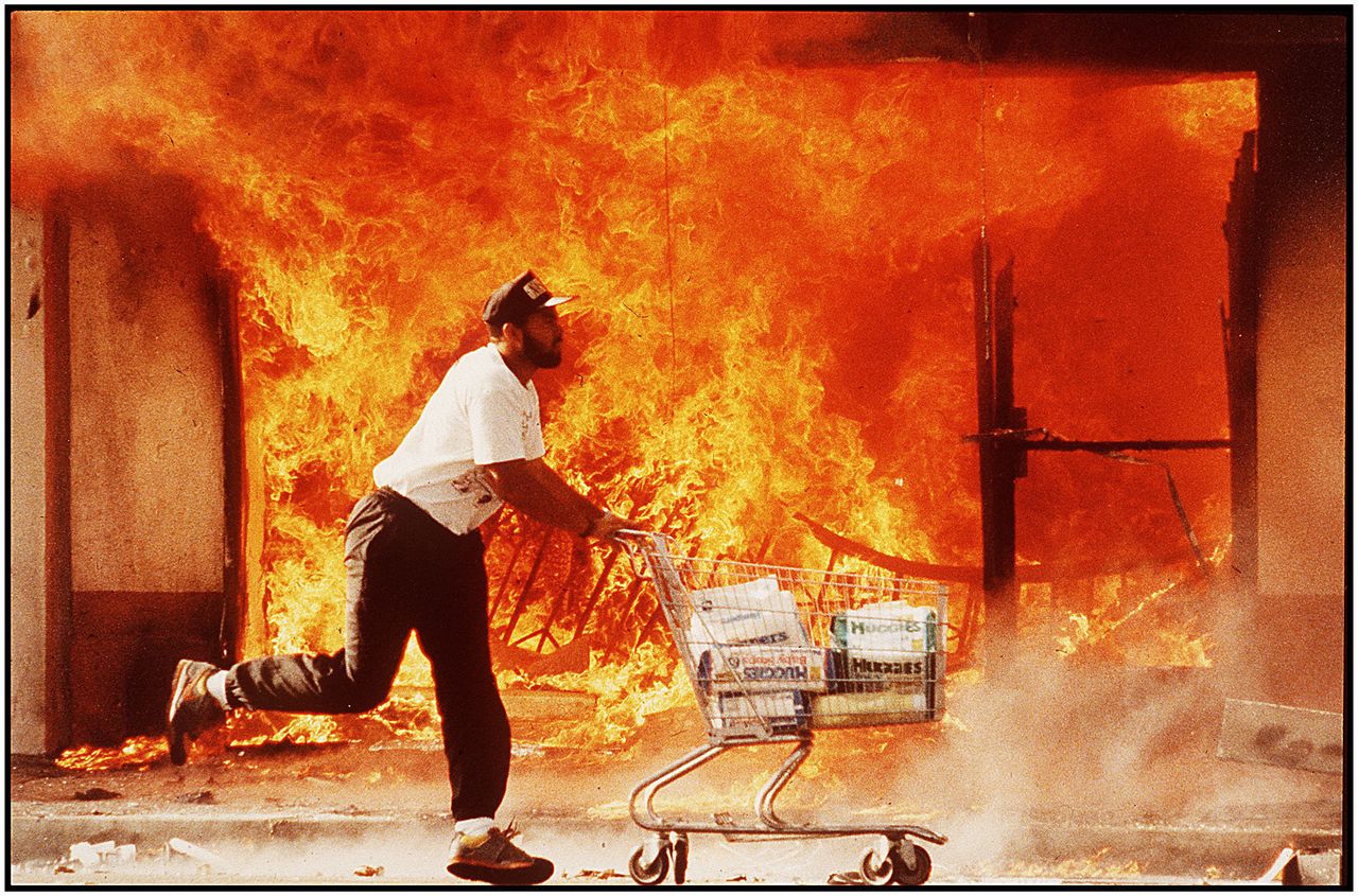 "The second day of the riots on 3rd street, I photographed this guy running past a burning Jon's market with a shopping cart full of diapers. I affectionately call this image 'A Huggies Run,'" says Kirk McKoy, who took this photo on April 30, 1992.