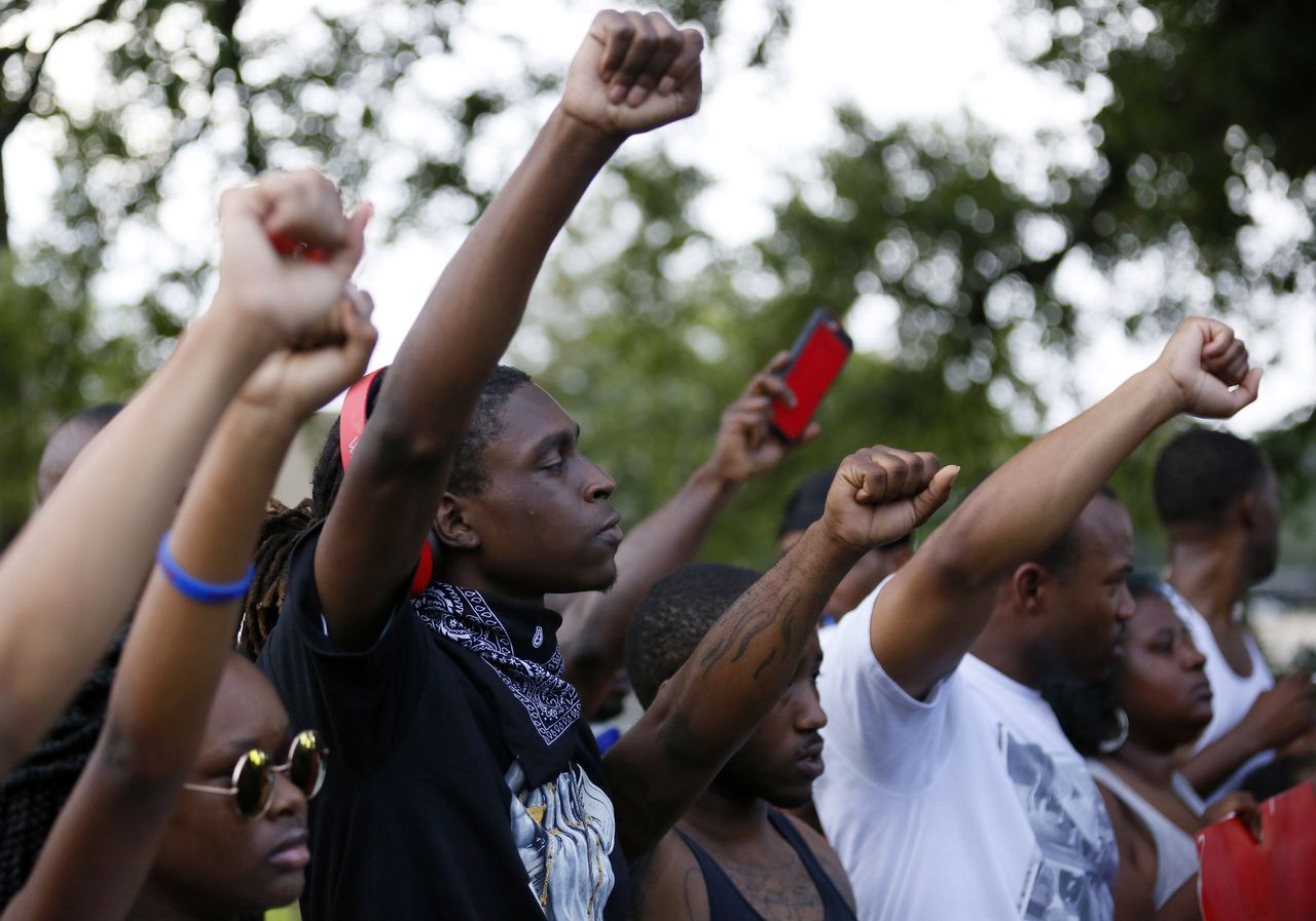 Protesters stand united with their fists raised at a Black Lives Matter rally.
