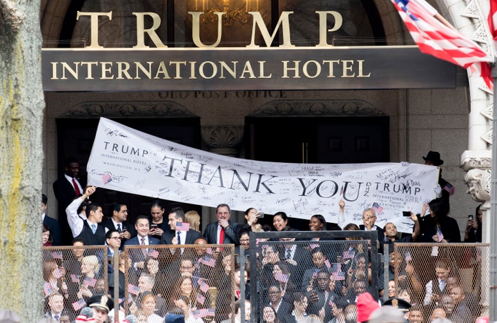 Trump International Hotel employees cheer during the Inaugural Parade on Jan. 20. His hotel has seen a boom in business from visiting dignitaries.