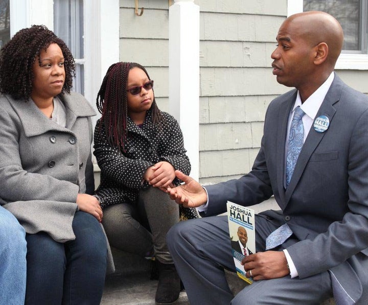 Joshua Hall, right, speaks to voters on the campaign trail. He became the third Working Families Party candidate to win a legislature seat on Tuesday.