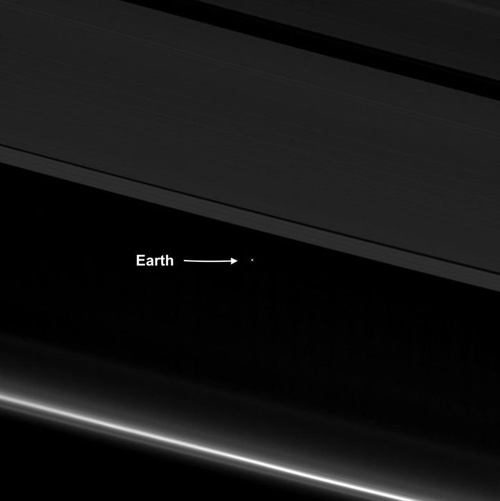 An April 12 image from NASA's Cassini spacecraft shows Earth as a point of light between the icy rings of Saturn. Cassini was