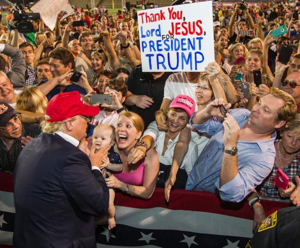 Donald Trump greets an enthusiastic crowd of supporters on August 21, 2015 in Mobile, AL. The Terror Management Theory suggests that individuals strongly associate with political figures if they believe they are part of a greater cause that will give their life enhanced meaning (e.g., waging the fight between good and evil). 