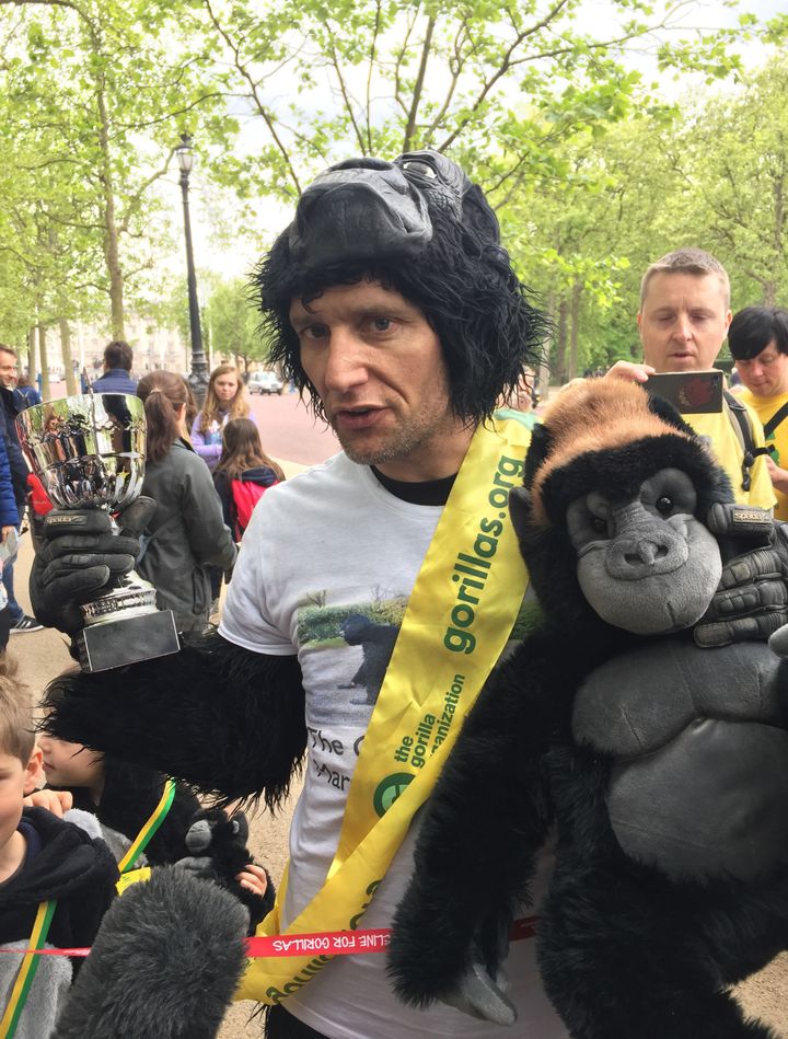 Metropolitan Police officer Tom Harrison, who goes by the name Mr Gorilla, celebrates after crawling across the finish line in The Mall in a gorilla costume to complete the London Marathon.
