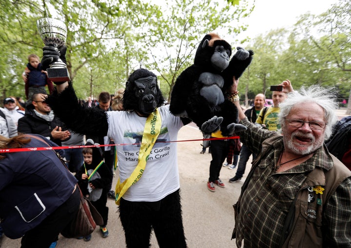 Harrison poses for photos after he was handed a trophy at the finish line. He was met by conservationist Bill Oddie, right.