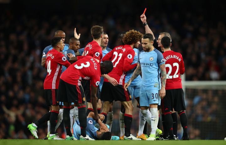 Players from both sides react as Manchester United midfielder Marouaine Fellaini is shown a red card.