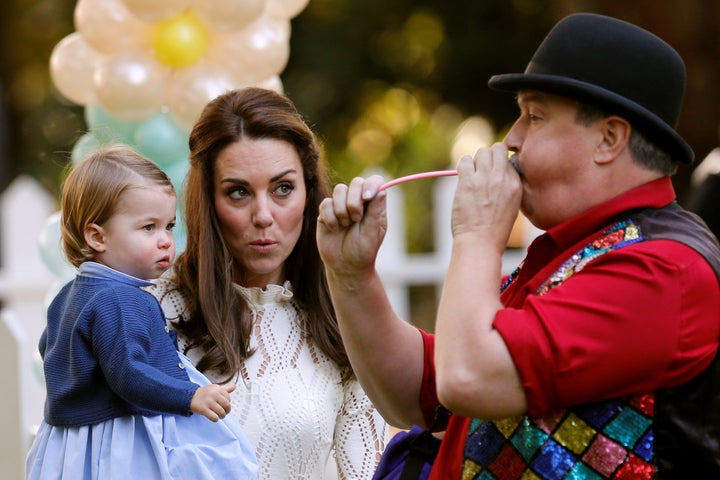 Catherine, Duchess of Cambridge, and Princess Charlotte watch a man inflate a balloon at a children's party on Sept. 29, 2016.