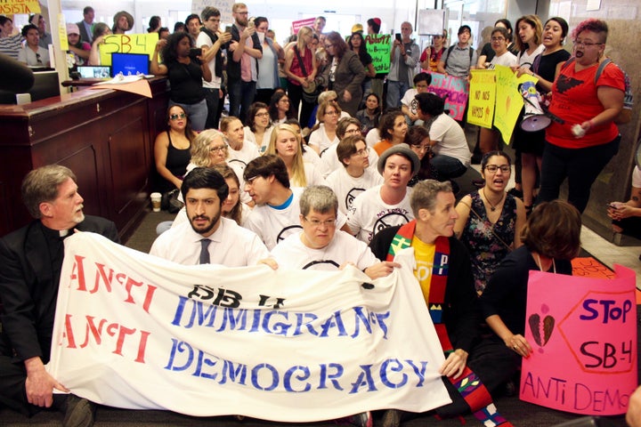 Immigrant rights rights activists and faith leaders stage a sit in at the offices of the Texas governor on May 1, 2017. 