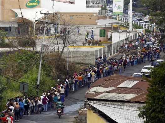 Venezuelans waiting in long lines for food.
