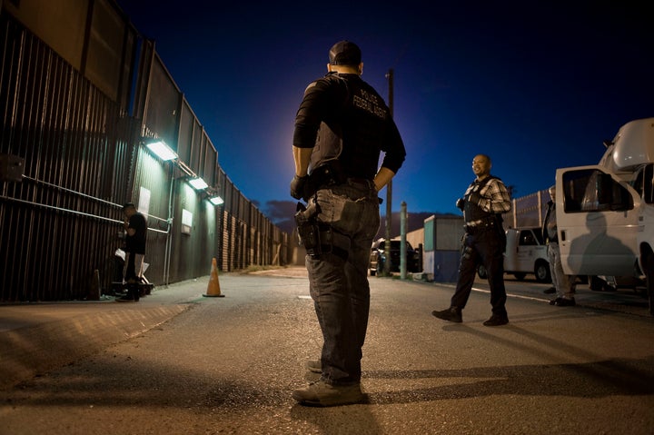 U.S. Immigration and Customs Enforcement agents speak as an undocumented man is being deported to Mexico at the U.S.-Mexico b