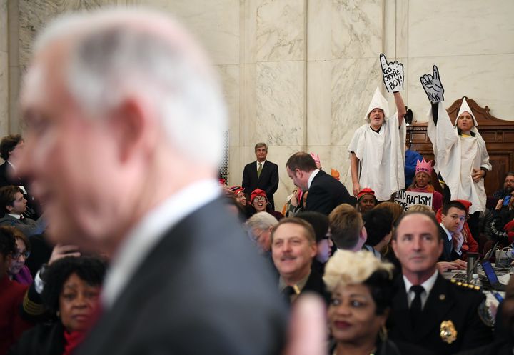 Jeff Sessions is seen before his attorney general confirmation hearing as demonstrators dressed as KKK members protest at the Russell Senate Office Building on Jan. 10.