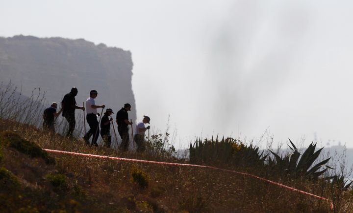 Members of Scotland Yard search a hill during the hunt for missing British girl Madeleine McCann in Praia da Luz, near Lagos, on June 8, 2014