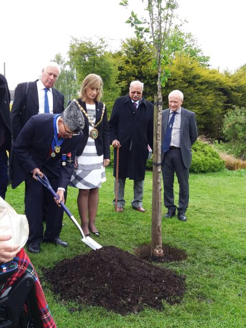 <p>Shera, while wearing a Pakistani Jinnah cap, plants a friendship tree in the borough of Rugby at a 2017 ceremony conferring him with the honor "Freedom of the Borough of Rugby" for his dedication to the borough and to building bridges. A delegation, including former Pakistani High Commissioner Wajid Shamsul Hasan, looks on. </p>