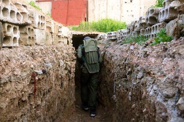 An opposition forces member breaks through in a tunnel as clashes between opposition forces and Assad regime forces continue