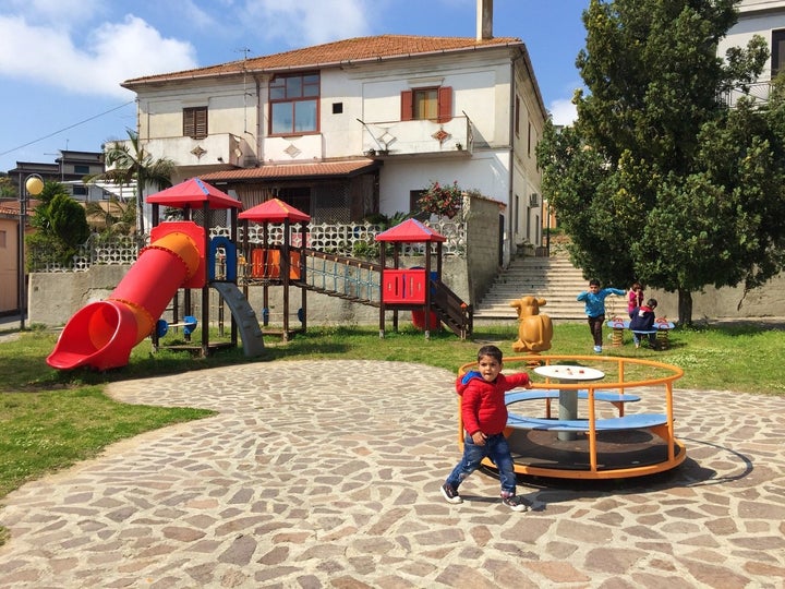 Ayan and Atya’s children, Ahmad, 3 (foreground) and Ali, 8 (running) playing in a park in Riace, Italy.