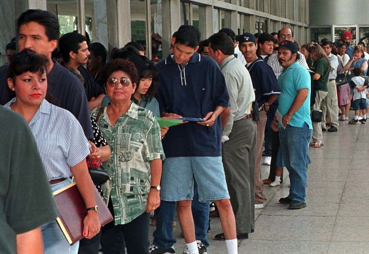 Immigrants, who qualify for residency in the U.S. but don't have their legal papers, stand in line at immigration offices in Los Angeles.
