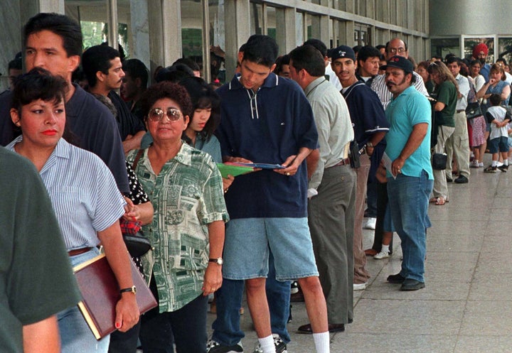 Immigrants, who qualify for residency in the U.S. but don't have their legal papers, stand in line at immigration offices in