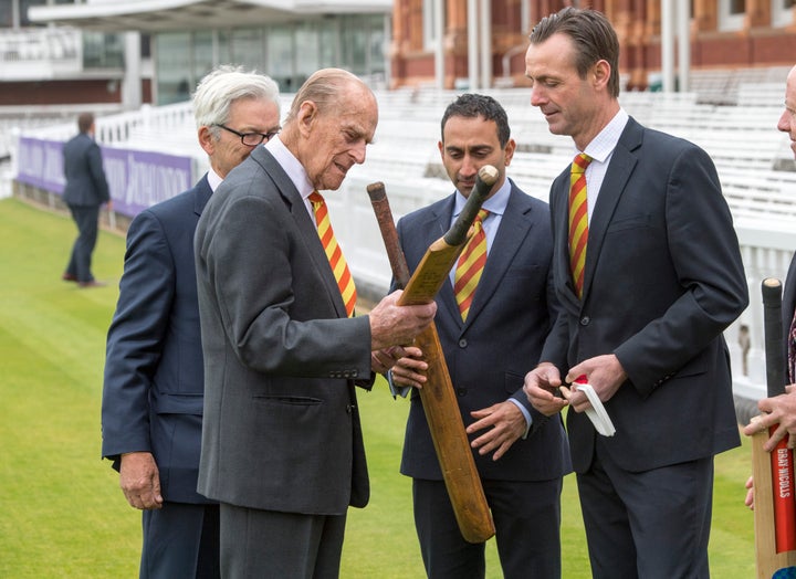 The Prince examines bats at the cricket ground