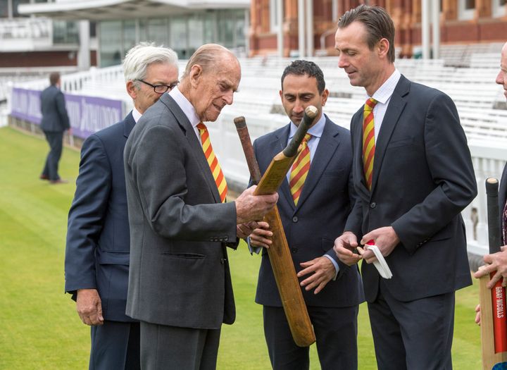 The Prince examines bats at the cricket ground